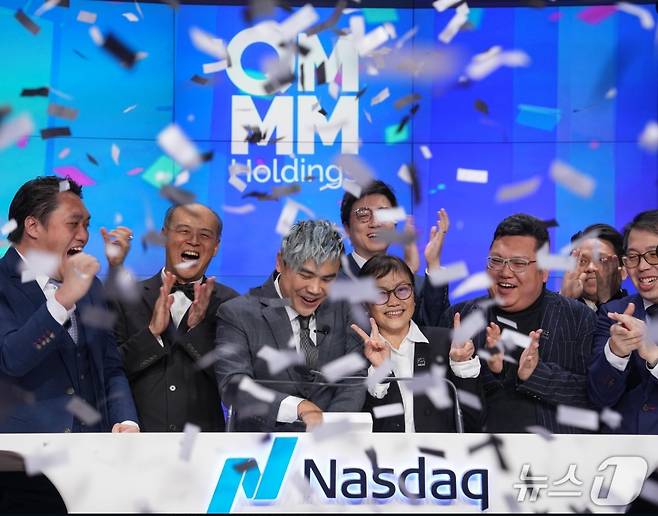 QMMM 상장 당시 기뻐하고 있는 직원들 - 회사 홈피 갈무리