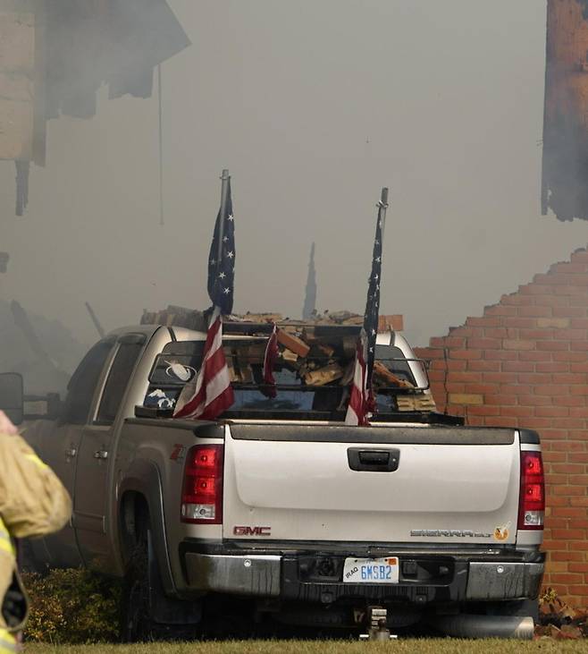28일 총격 및 방화 사건이 벌어진 미국 미시간주 그랜드블랭크의 예수그리스도후기성도교회(모르몬교) 건물에서 연기가 나고 있다. 이 사건으로 최소 4명이 숨지고 8명이 다쳤다. 아래쪽 사진(위쪽 사진 점선 안)은 현장에서 발견된 총격범 토머스 샌퍼드의 트럭. 그랜드블랭크=AP 뉴시스