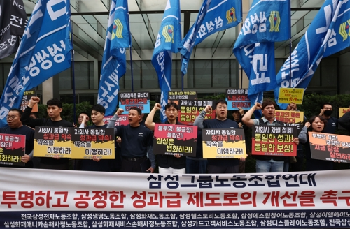 30일 서울 서초구 삼성전자 서초사옥 앞에서 열린 투명한 성과급 제도로의 개선을 촉구하는 기자회견에서 삼성그룹노조연대 등 참석자들이 구호를 외치고 있다. [연합뉴스]