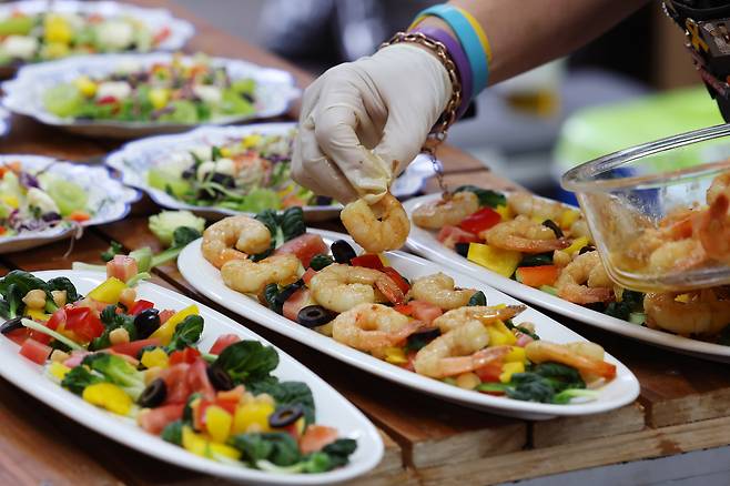 주휘씨가 지난 22일 경북 구미 한국옵티칼 농성장에서 풀코스 두 번째 순서로 나갈 새우 세비체를 담아내고 있다.