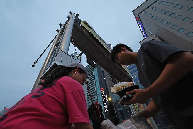 고진수 민주노총 세종호텔노조 지부장이 고공농성 하는 철제 구조물로 저녁밥을 올리고 있다.