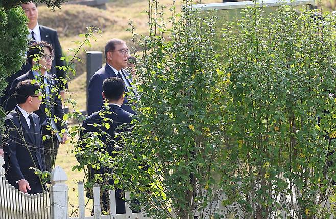 Japanese Prime Minister Shigeru Ishiba (second row, right) visits the grave of the late Lee Soo-hyun, a Korean student who was killed while rescuing a Japanese man at a train station in Tokyo in 2001, during his visit to Busan for a summit with President Lee Jae Myung on Tuesday. (Yonhap)