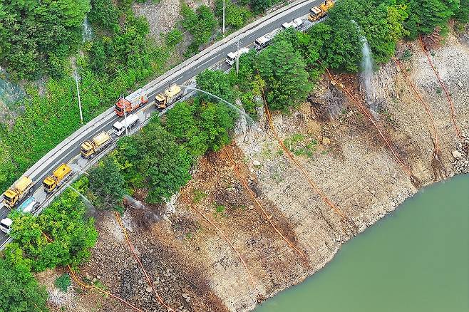 지난 9일 강원 강릉시 오봉저수지에서 육·해·공군과 소방, 전국 지자체 및 기관이 지원한 살수차들이 수위를 높이고자 물을 쏟아붓고 있다. 연합뉴스