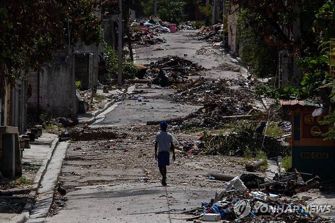 25일(현지시간) 아이티 수도 포르토프랭스 거리 지나가는 주민 [포르토프랭스 AFP=연합뉴스. 재판매 및 DB 금지]