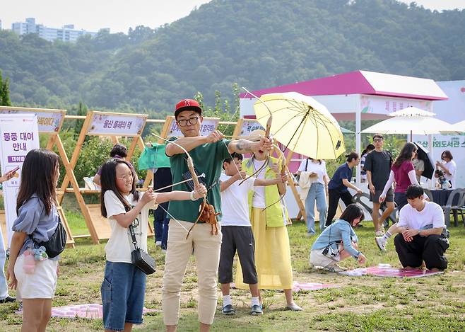 지난달 14일 울산야외도서관 '소풍' 행사가 열리고 있는 태화강국가정원 소풍마당에서 시민들이 활쏘기, 투호 등 전통 놀이 체험을 하고 있다. 울산매일 포토뱅크