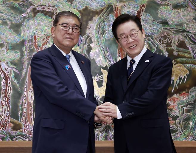 President Lee Jae Myung, right, and Japanese Prime Minister Shigeru Ishiba shake hands ahead of their bilateral summit at Nurimaru APEC House in Busan on Sept. 30. [JOINT PRESS CORPS]