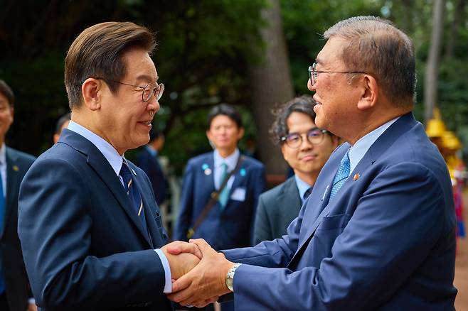 President Lee Jae Myung, left, greets Japanese Prime Minister Shigeru Ishiba at the Nurimaru APEC House in Busan ahead of their bilateral summit on Sept. 30. [PRESIDENTIAL OFFICE]