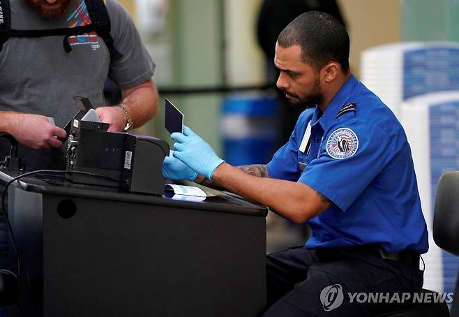 미국 교통안전청(TSA) 직원이 연방정부 셧다운(일시적 업무정지) 기간이었던 지난 2019년 1월 6일 워싱턴DC의 레이건공항에서 여행객의 서류를 살펴보고 있다. [로이터=연합뉴스 자료사진. 재판매 및 DB 금지]