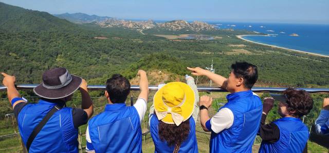 ▲ 고성군 금강회 회원들이 24일 DMZ평화의 길 탐방에 나선 후 717금강산 전망대에서 함명준 군수 등과 함께 멀리 해금강과 감호를 조망하며 평화통일을 염원했다.  김주현 기자