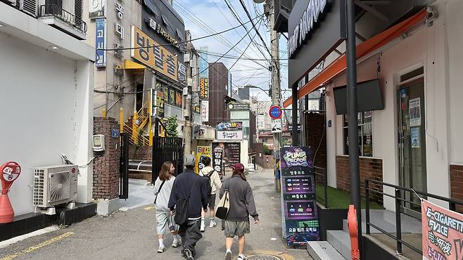 Foreigners walk past an room escape in Hongdae in western Seoul on Sept. 29. [WOO JI-WON]