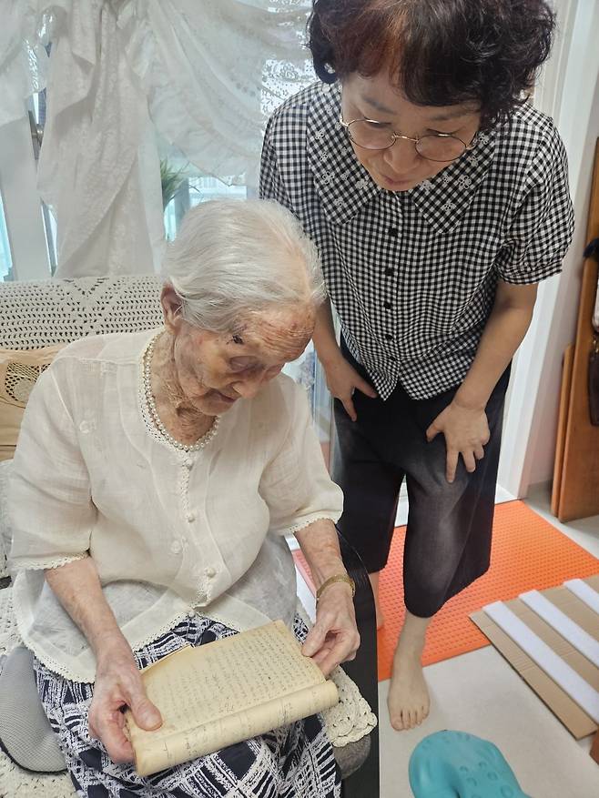 우을순 할머니가 성경을 읽는 모습을 딸인 최정미 권사가 지켜보고 있다.