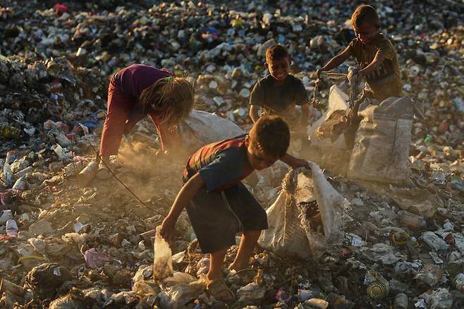 [칸유니스=AP/뉴시스] 지난달 30일(현지 시간) 가자지구 남부 칸유니스에서 팔레스타인 난민 어린이들이 난민촌 근처 쓰레기 더미에서 땔감으로 사용할 장작과 플라스틱을 찾고 있다. 하마스는 미국이 제안한 가자 종전안에서 무장 해제 등 일부 조항 수정을 요구한 것으로 알려졌다. 2025.10.02.