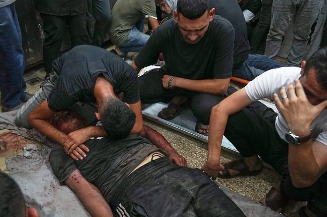 [데이르알발라=AP/뉴시스] 지난달 30일(현지 시간) 가자지구 중부 데이르알발라의 알아크사 병원에서 팔레스타인 주민들이 숨진 가족 주변에 모여 오열하고 있다. 희생자는 이스라엘의 목공소와 카페 공습 이후 병원으로 옮겨졌다. 2025.10.02.