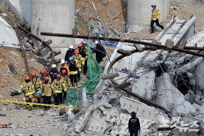 지난 2월 25일 구조물 붕괴 사고가 발생한 경기 안성 서운면 산평리 인근 고속도로 공사 현장에서 소방대원들이 수습한 시신을 운구하고 있다. 안성=박종민 기자