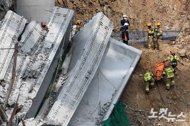 지난 2월 25일 구조물 붕괴 사고가 발생한 경기 안성 서운면 산평리 인근 고속도로 공사 현장에서 소방대원들이 시신 수습을 위한 들것을 옮기고 있다. 안성=박종민 기자