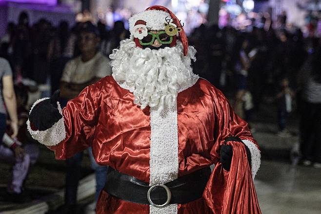 1일(현지시각) 베네수엘라 마라카이보에서 열린 크리스마스 행사에서 한 사람이 산타 클로스 복장을 하고 있다. EPA 연합뉴스