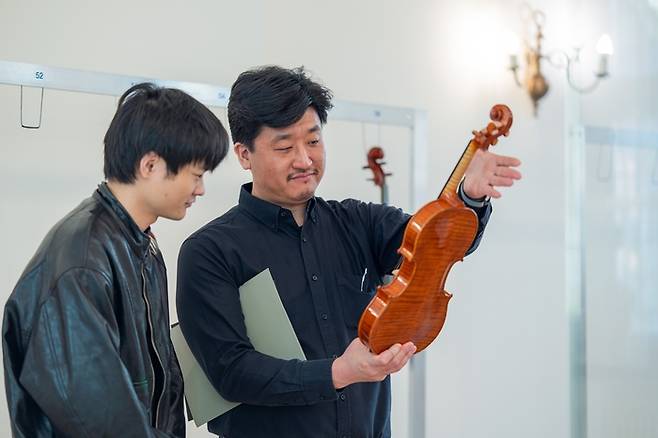 현악기 제작자 박지환씨(오른쪽)가 바이올린을 살펴보고 있다. [Wieniawski Society]