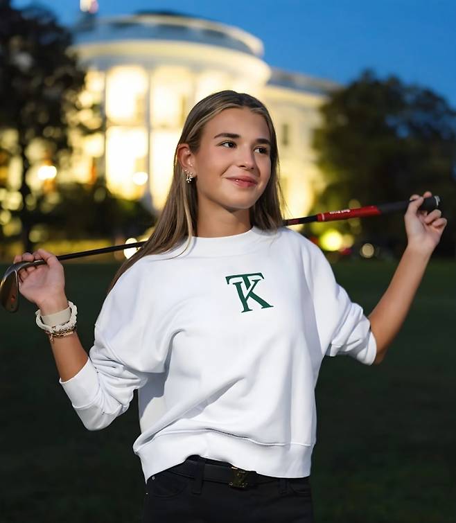 백악관을 배경으로 자신의 브랜드 스웨터를 입고 포즈를 취한 카이 트럼프.  유튜브 캡처