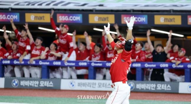 홈런을 날린 뒤 두 팔을 뻗고 기뻐하는 이율에와 환호하는 벤치의 동료들. /사진=강영조 선임기자