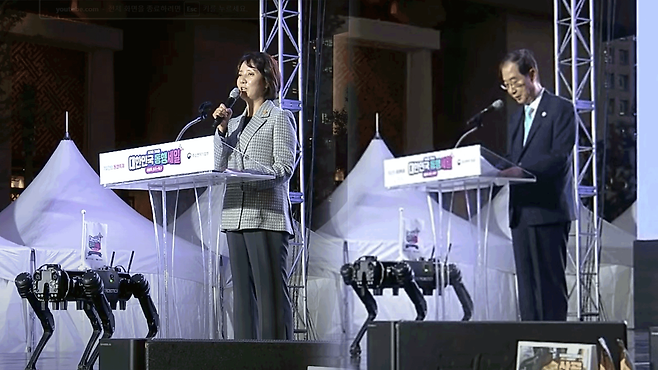 중소벤처기업부가 2022년 8월 31일 서울 광화문에서 개최한 ‘동행축제’ 개막식에서 축사를 하는 이영 전 중기부 장관과 한덕수 전 국무총리 옆으로 ‘로봇개’가 나란히 선 모습. (중기부 유튜브 갈무리)