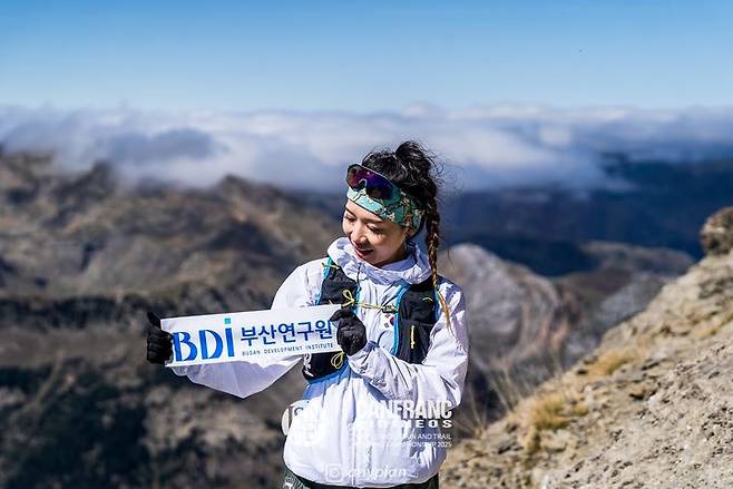 [부산=뉴시스] 김진희 연구원은 지난달 25일~28일까지 스페인 칸프랑크에서 열리는 '2025 세계 산악·트레일러닝 선수권대회(WMTRC)' 한국 국가대표로 참가했다. 대회 전 훈련에서 '부산연구원' 플랜카드를 들고 있는 김 연구원. (사진=김진희 연구원 본인, 조준 작가 제공) 2025.10.04. photo@newsis.com *재판매 및 DB 금지