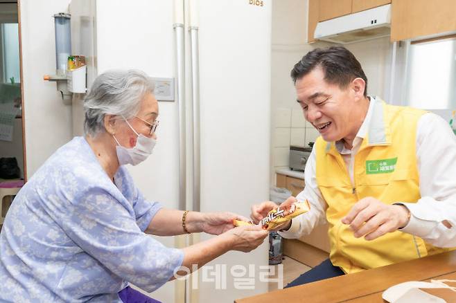지난해 8월 새빛돌봄 서비스를 이용하는 가구를 방문한 이재준 수원시장에게 어르신이 아이스크림을 건네고 있다.(사진=수원시)