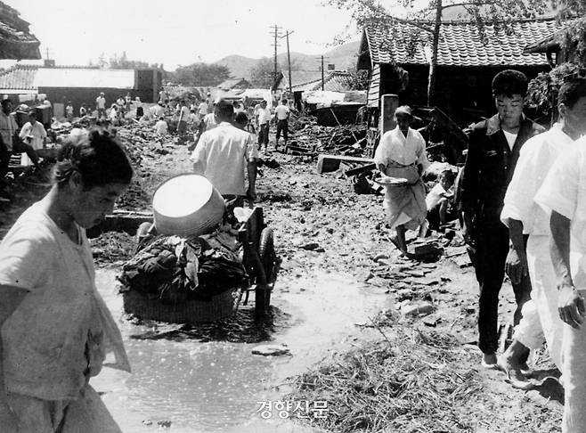 사라호 태풍으로 인하여 부서진 가옥들 사이로 집기를 정리하는 시민들. 경향신문 자료사진
