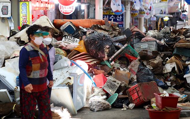추석 연휴를 앞두고 경북 포항시 구룡포 시장 골목에 태풍 힌남노로 침수피해를 본 각종 집기와 대목 맞이 상품들이 가득 쌓여 있다.  연합뉴스 제공