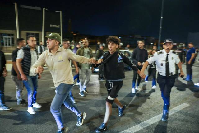 TOPSHOT - Members of the security forces detain a protester during a youth-led demonstration demanding reforms in the healthcare and education sectors in Sale on October 1, 2025. Two people were killed when officers opened fire on a group of people attempting to "storm" a police station in Morocco on October 1, state media said, as protests -- sometimes violent -- roil the north African nation. Demonstrations have convulsed Morocco for several days, urged on by the GenZ 212 group, a recently formed collective based on the Discord web platform whose organisers remain unknown. (Photo by Abdel Majid BZIOUAT / AFP) <Copyright (c) Yonhap News Agency prohibits its content from being redistributed or reprinted without consent, and forbids the content from being learned and used by artificial intelligence systems.>