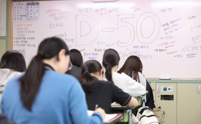 지난달 24일 경북 한 고등학교 3학년 교실 칠판에 수능 D-50 다짐 메시지가 적힌 가운데 고3 수험생들이 자습하고 있다. 연합뉴스
