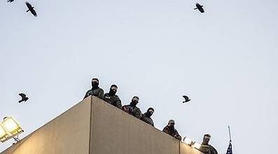 지난 5일 미국 오리건주 포틀랜드의 이민세관단속국(ICE) 시설 옥상에서 경찰과 연방 공무원들이 경비를 서고 있다. 연합뉴스