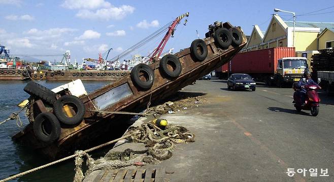 부산 영도구 봉래동 보세창고 앞 해안에 바지선 한 척이 여전히 방치되어 있어 지나는 차량들을 위협하고 있다. 동아일보 DB