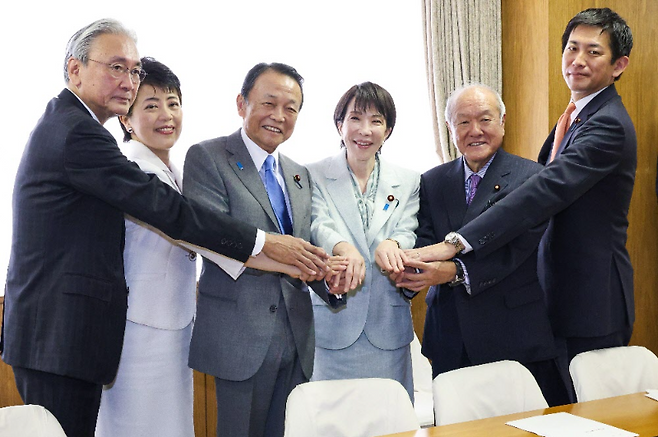 4일 일본 집권 자민당 총재로 선출된 다카이치 사나에 총재(왼쪽 네번째)가 7일 도쿄 당사에서 간부 인사를 단행한 후 이들과 손잡고 있다. 왼쪽부터 후루야 게이지 선거대책위원장, 아리무라 하루코 총무회장, 아소 다로 부총재 겸 전 총리, 다카이치 총재, 아소 부총재의 처남 스즈키 슌이치 간사장, 고바야시 다카유키 정무조사회장. 아사히신문 제공