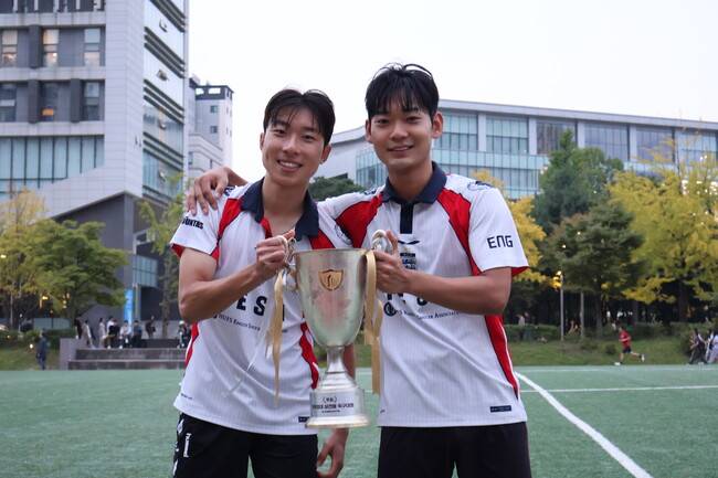 [사진 = HUFSPORTS] HESA 주장 정준(왼쪽)과 극장골 주인공 최원준(오른쪽)이 우승 트로피를 들고 포즈를 취하고 있다