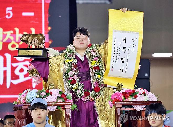 추석 백두장사 등극한 김민재 (서울=연합뉴스) 8일 울산 울주종합체육센터에서 열린 '위더스제약 2025 울주추석장사씨름대회' 백두장사(140kg이하)에 등극한 김민재(영암군민속씨름단)가 장사인증서와 황소트로피를 들고 기념사진을 찍고 있다. 2025.10.8 [대한씨름협회 제공. 재판매 및 DB 금지] photo@yna.co.kr
