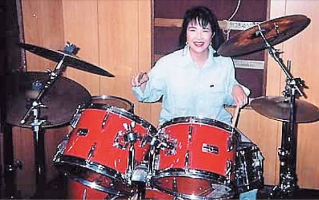 다카이치 사나에 신임 자민당 총재가 2010년 전후 자신의 스포츠카 ‘수프라’ 앞에서 찍은 사진. 아래 사진은 대학 시절 밴드 활동을 했던 다카이치가 드럼을 연주하는 모습./베스트카·다카이치 사나에 홈페이지