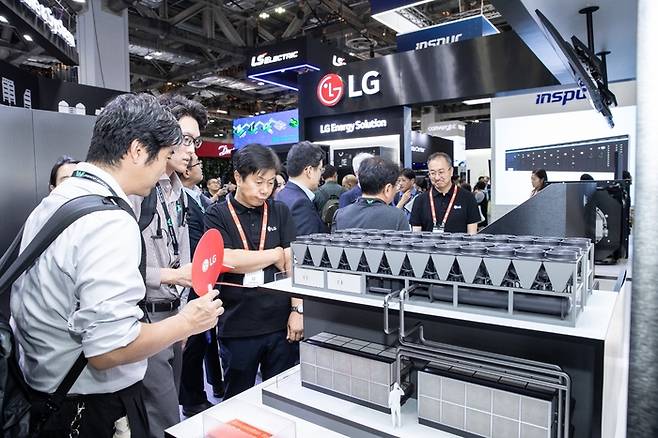 LG전자와  LG CNS, LG에너지솔루션이 8일부터 양일간 싱가포르에서 열린 '데이터센터 월드 아시아(Data Center World Asia) 2025'에서 '원(One) LG' 통합 솔루션을 선보였다. 관람객이 평택 칠러공장 내 마련된 'AI 데이터센터 전용 테스트베드' 축소 모형을 살펴보는 모습.