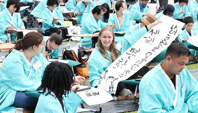 제579돌 한글날을 맞이한 9일 서울 종로구 광화문광장에서 열린 ‘2025 제 16회 광화문광장 휘호대회‘에 참가한 외국인들이 한글을 쓰고 있다. 이번 대회는 총 35개국 약 400여명이 참가했다. [사진 뉴스1]