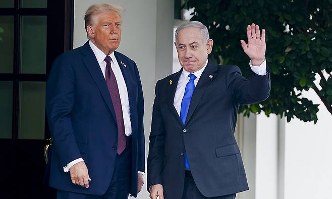 29일(현지시간) 미국 백악관에 도착한 베냐민 네타냐후 이스라엘 총리(오른쪽)가 도널드 트럼프 미국 대통령이 지켜보는 가운데 취재진에게 손을 흔들어 인사하고 있다. EPA연합뉴스