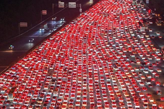 中 국경절 귀경차량 인산인해 - 중국 국경절 연휴기간이던 지난 7일 동부 안후이성 추저우의 우장 요금소에서 정체된 차량들이 붉은 불빛을 비추며 길게 꼬리를 물고 서 있다. 추저우 AP 연합뉴스