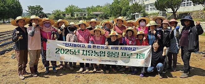 ▲ 9월 30일 경북 의성군 서부1리 치매보듬마을 옛 이두초등학교 운동장에서 열린 '2025년 치유농업 힐링 프로그램' 고구마 수확행사에서 마을 어르신들과 관계자들이 함께 수확의 기쁨을 나누며 기념촬영을 하고 있다. 의성군 제공