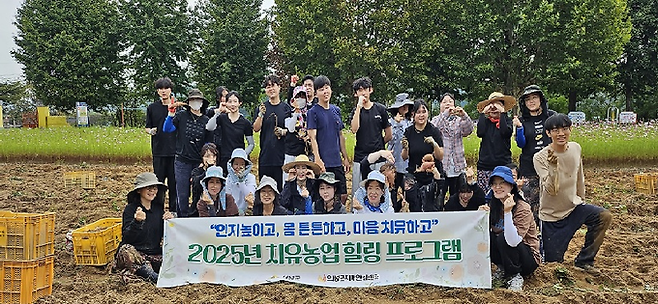 ▲ 9월 30일 경북 의성군 서부1리 치매보듬마을 옛 이두초등학교 운동장에서 열린 '2025년 치유농업 힐링 프로그램' 고구마 수확행사에 참여한 관계자들이 함께 수확의 기쁨을 나누며 기념촬영을 하고 있다. 의성군 제공