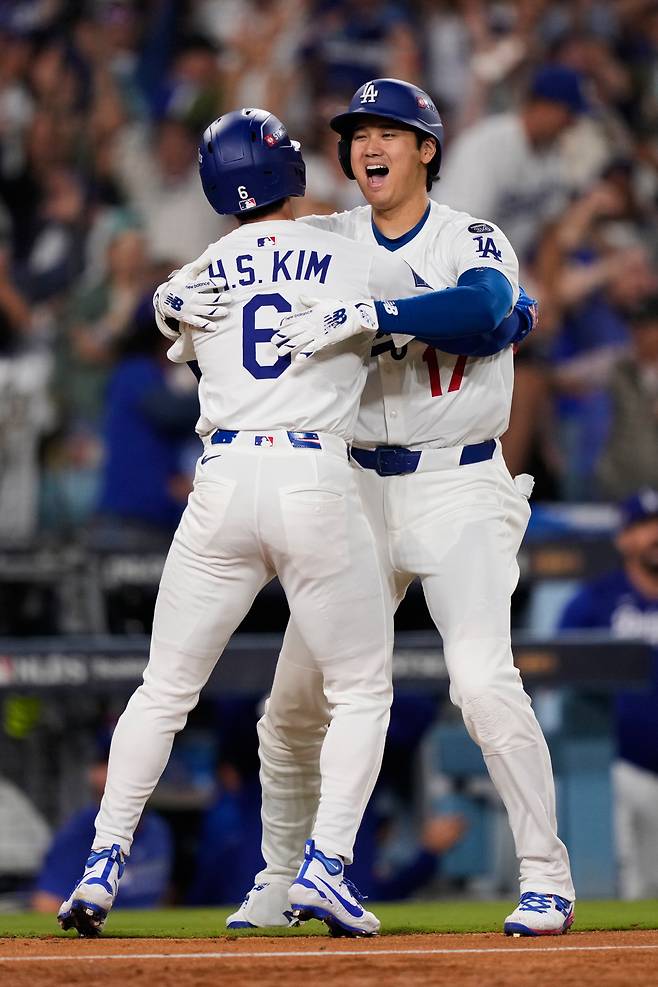 LA 다저스 김혜성이 10일(한국시각) 다저스타디움에서 열린 필라델피아 필리스와의 디비전시리즈 4차전서 연장 11회말 1루 대주자로 기용돼 맥스 먼시의 중전안타로 3루까지 진루한 뒤 앤디 파헤스의 땅볼을 잡은 상대 투수 오라이온 커커링의 실책으로 끝내기 득점을 올리고 오타니 쇼헤이와 얼싸안고 기뻐하고 있다. AP연합뉴스