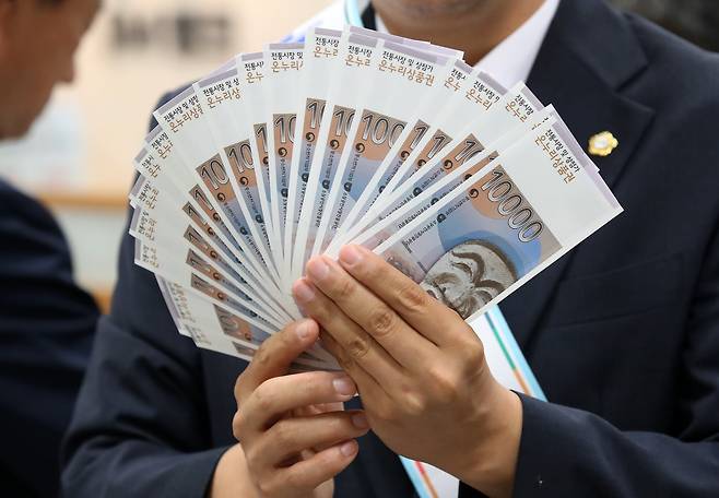 지난달 열린 '추석맞이 전통시장 온누리상품권 구매 행사'에서 참석자들이 온누리상품권을 펼쳐 보이고 있다./뉴스1