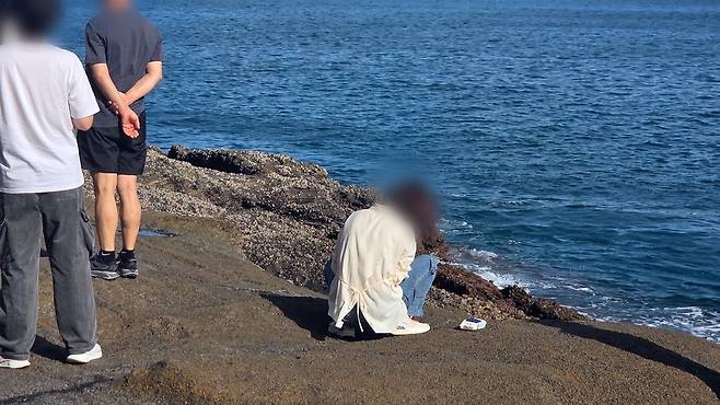 지난 추석 연휴 기간 제주 용머리해안에서 한 여성이 여아 용변을 뉘는 모습. 이곳은 천연기념물로 지정돼 보호받는 지역이다. 보배드림 갈무리