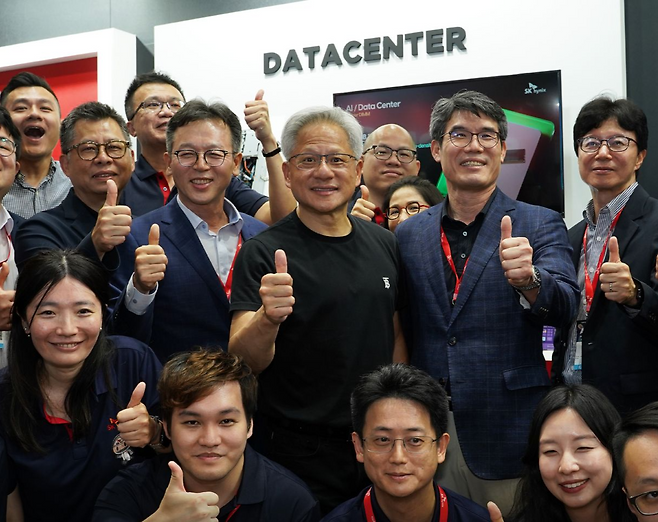 젠슨 황 엔비디아 최고경영자(CEO)가 지난 5월 20일 대만 타이베이에서 열린 IT 전시회 ‘컴퓨텍스 2025’에서 SK하이닉스 부스를 깜짝 방문해 임직원들과 기념촬영하고 있다. [SK하이닉스 SNS]