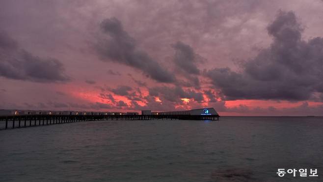 로빈슨클럽 몰디브의 선다우너바에서 바라본 석양 배경의 해상빌라들.