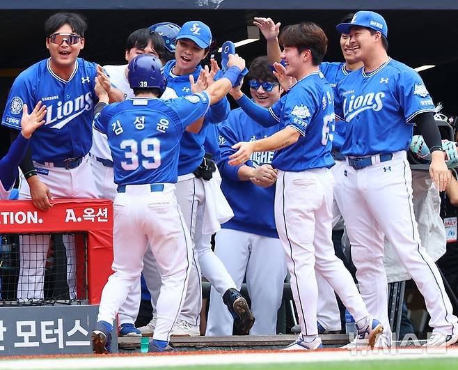 [서울=뉴시스] 박주성 기자 = 11일 인천 미추홀구 SSG랜더스필드에서 열린 2025 KBO 포스트시즌 준플레이오프 2차전 삼성 라이온즈와 SSG 랜더스의 경기, 4회초 원아웃 주자 2, 3루에서 삼성 디아즈의 2타점 적시타 때 홈을 밟은 김성윤이 팀 동료와 기쁨을 나누고 있다. 2025.10.11. park7691@newsis.com