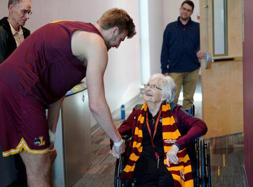 미국 시카고에 있는 로욜라 대학교 남자 농구팀의 전담&nbsp;교목을 지낸&nbsp;진 돌로레스 슈미트 수녀(오른쪽)가 103세이던 2023년 막 연습을 시작하려는 젊은 학생&nbsp;선수의 손을 붙잡으며&nbsp;격려하고 있다. AP연합뉴스