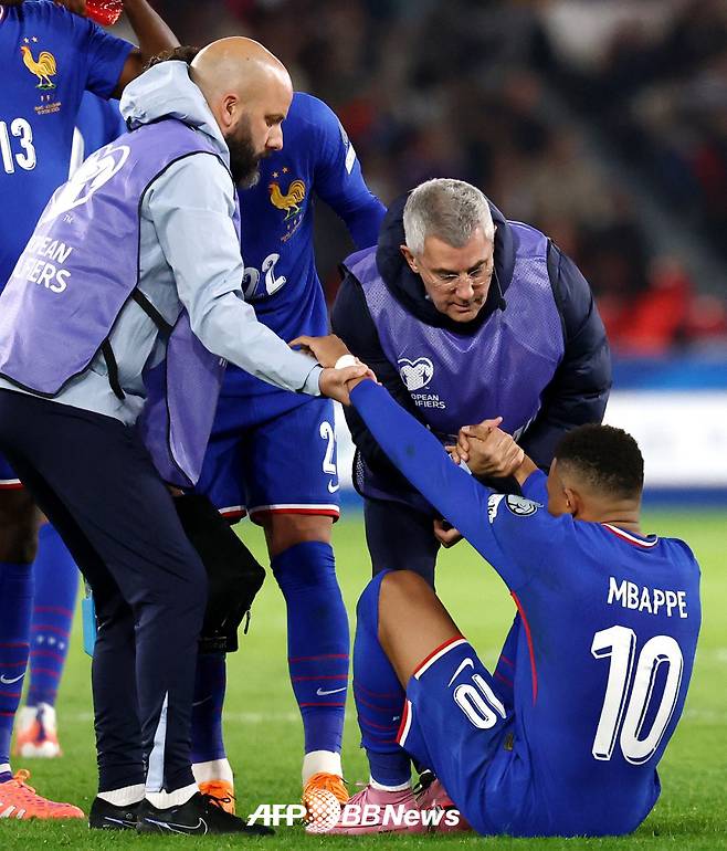 프랑스 대표팀 공격수 킬리안 음바페가 11일(한국시간) 프랑스 파리의 파르크 데 프랭스에서 열린 아제르바이잔과의 2026 국제축구연맹(FIFA) 북중미 월드컵 유럽 예선 3차전 도중 발목 부상으로 쓰러진 뒤 의료 스태프 부축을 받으며 일어서고 있다. /AFPBBNews=뉴스1